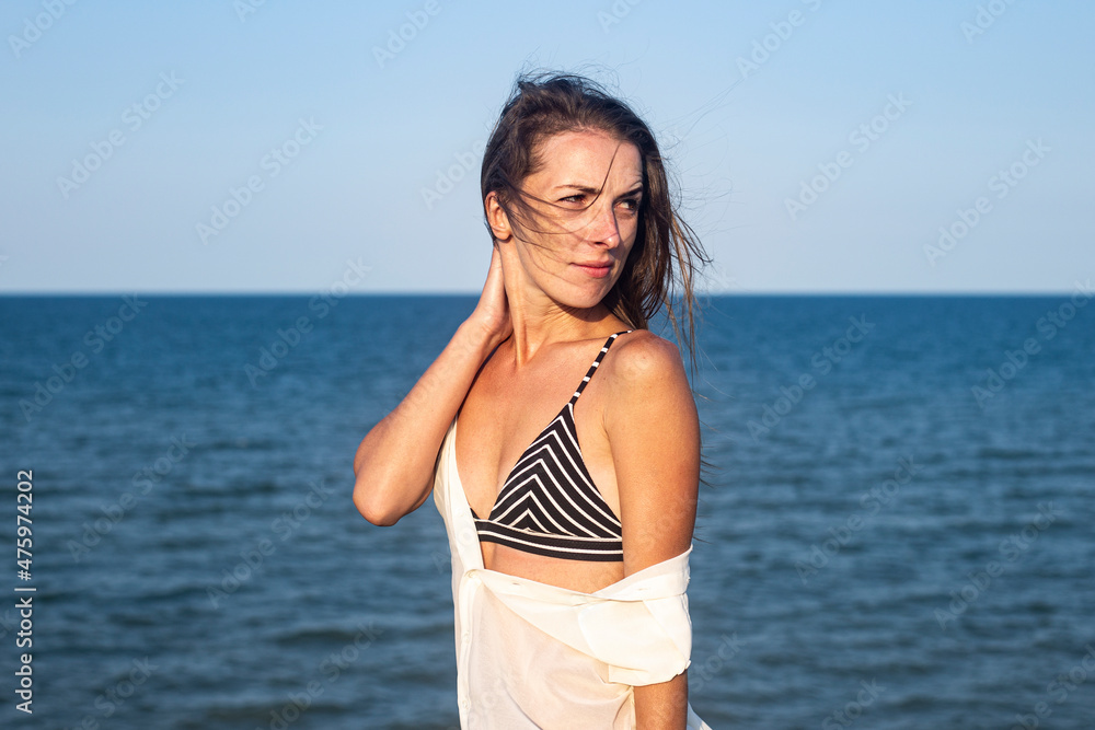 Beautiful sexy young woman in a light pareo on the background of the sea. Beautiful sexy young woman in a light pareo on the background of the sea.
