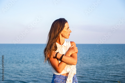 Fototapeta Naklejka Na Ścianę i Meble -  Beautiful young woman in denim shorts and shirt at the sea.
