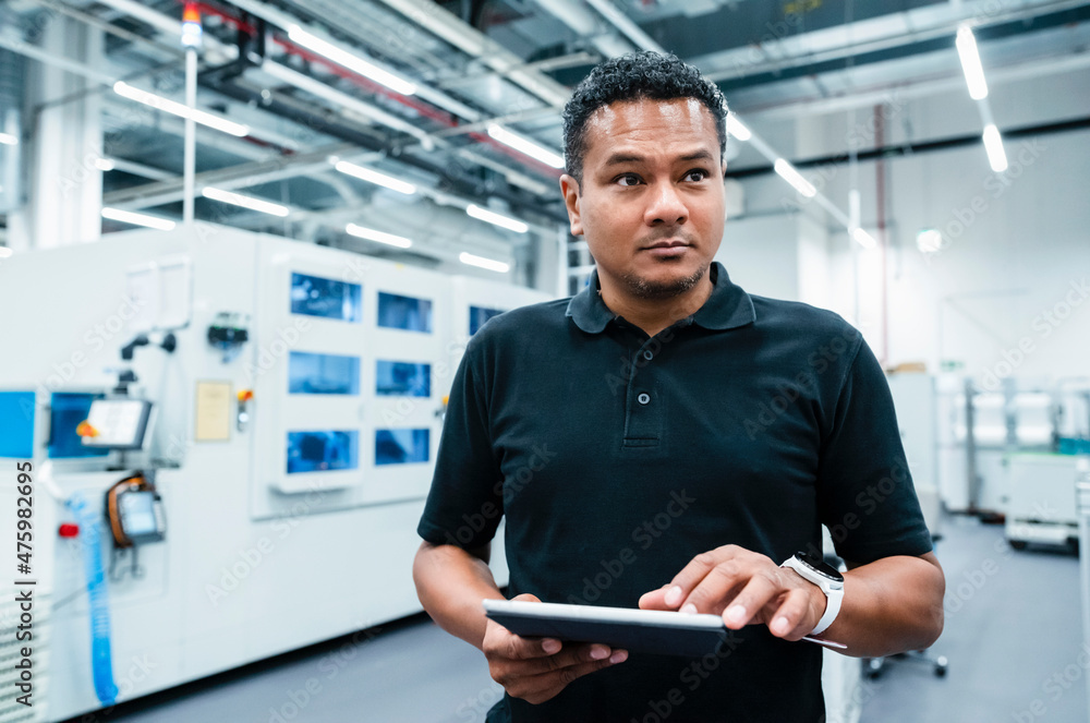 Maintenance engineer holding tablet PC at factory Maintenance engineer holding tablet PC at factory