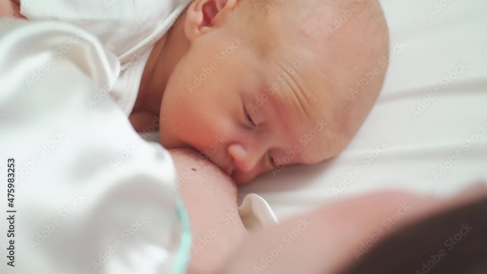 breastfeeding. close up. mother feeds the baby with breast milk lying in bed breastfeeding. close up. mother feeds the baby with breast milk lying in bed