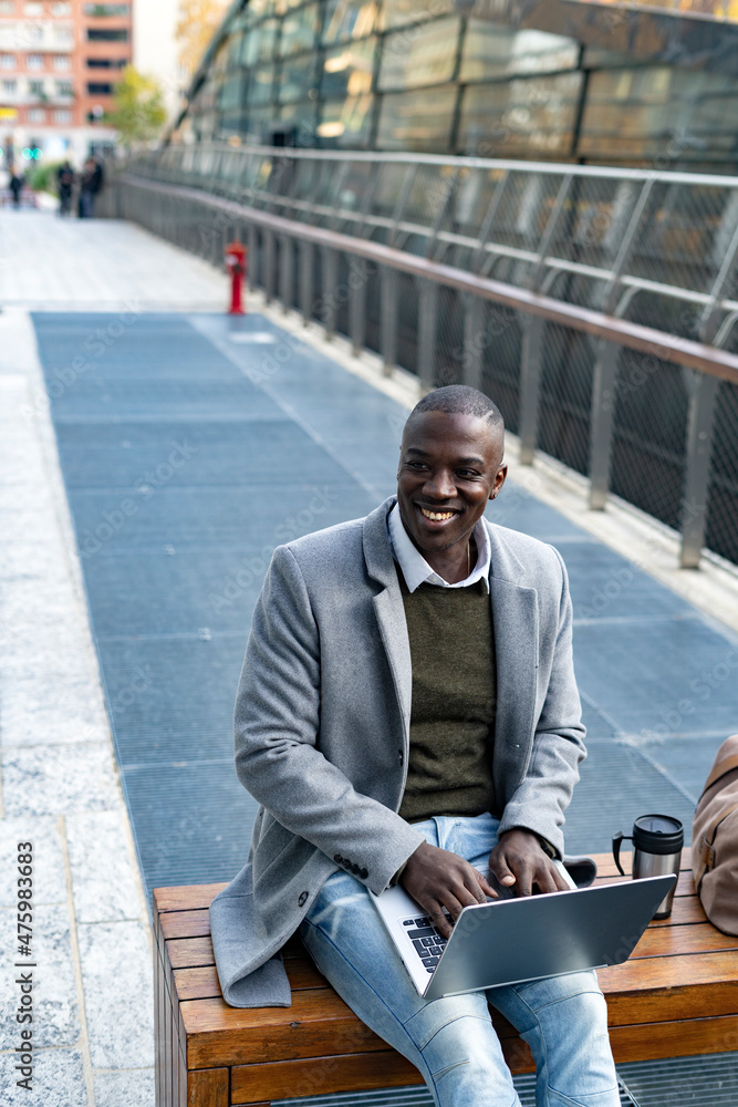 Contemplative businessman with laptop sitting on bench Contemplative businessman with laptop sitting on bench