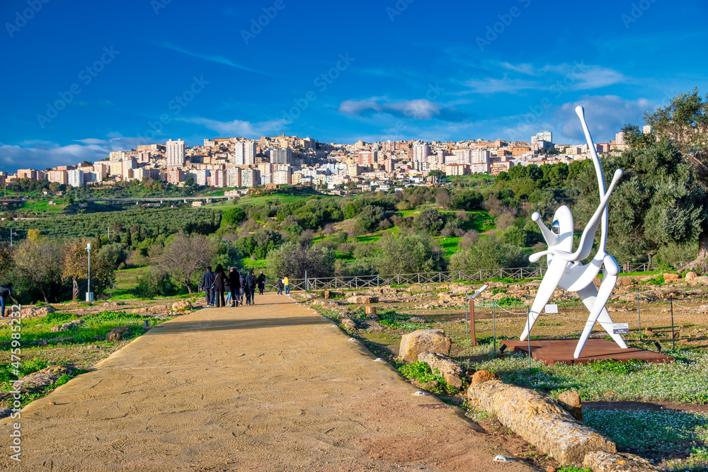 AGRIGENTO, ITALY - DECEMBER 12, 2021: Sculptures along the Valley of the Temples with city skyline on the background.
