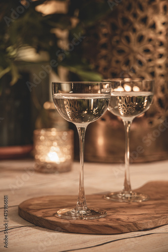 Close up shot of two martini cocktails in beautiful, vintage pony glass. Bokeh lights in background. Indoor, cozy, warm festive atmosphere, slightly faded.