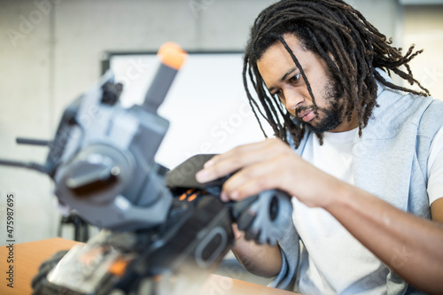 Technician with braided hair working with combat tank at workshop