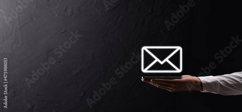 Businessman hand holding e-mail icon, Contact us by newsletter email and protect your personal information from spam mail. Customer service call center contact us concept