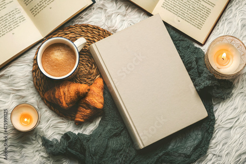 Top view of books,cup of coffee,croissants and candles. Selective focus photo