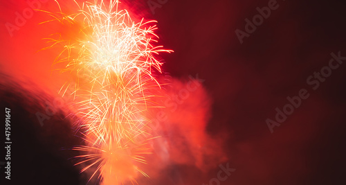 Fireworks banner. Scarlet illuminated background. Multicolored holiday lights panorama copy space. The concept of New Year  Christmas  Birthday  Wedding. Festive background with blurred lights