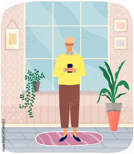 Young man surfing internet and communicating by phone typing message. Person spends time with smartphone standing at home in living room. Concept of using Internet application and modern gadgets
