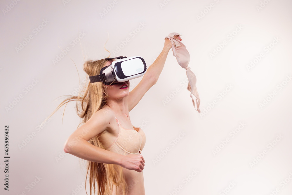 Naklejka premium Girl in virtual reality goggles holds bra