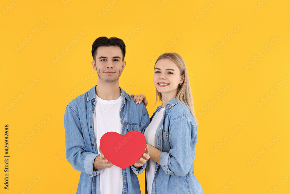 Cute couple with heart on yellow background Cute couple with heart on yellow background