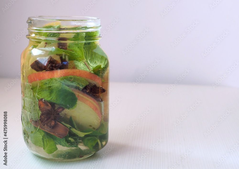 Mug of detox water or flavored water with red apple slices, mint leaves, anise stars, cinnamon stick Mug of detox water or flavored water with red apple slices, mint leaves, anise stars, cinnamon stick