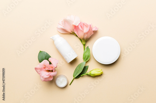 Composition with cosmetic products and beautiful roses on color background. Flat lay
