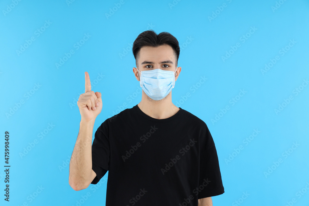 Young man in medical mask on blue background Young man in medical mask on blue background