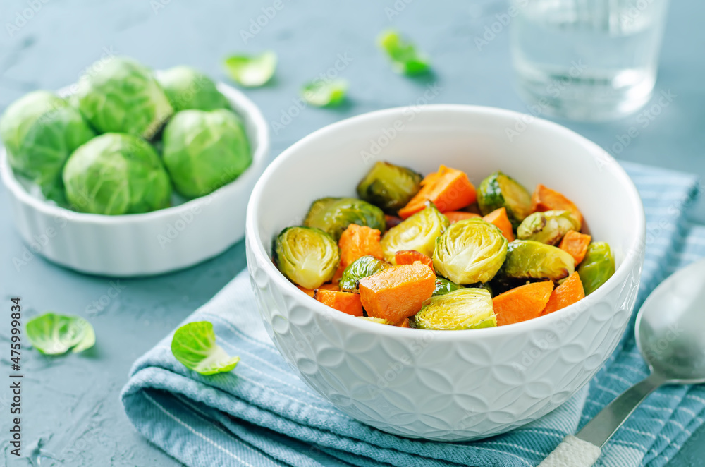 Roasted Sweet potato and Brussels Sprouts on a wood background Roasted Sweet potato and Brussels Sprouts on a wood background