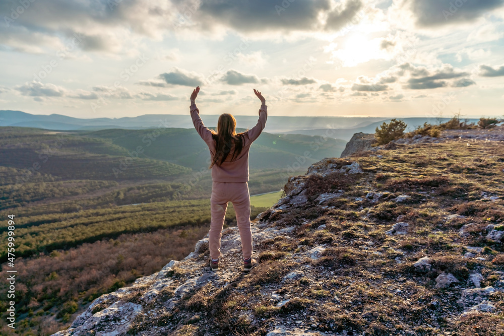 The girl at sunset. The girl stands with her back on the top of the ...
