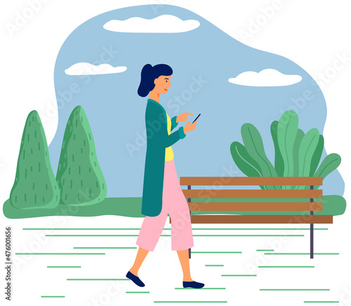 Young woman walking in park with mobile phone using smartphone to share posts in social networks, chatting with friends, sending message. Girl holds smart phone to make repost of video and news