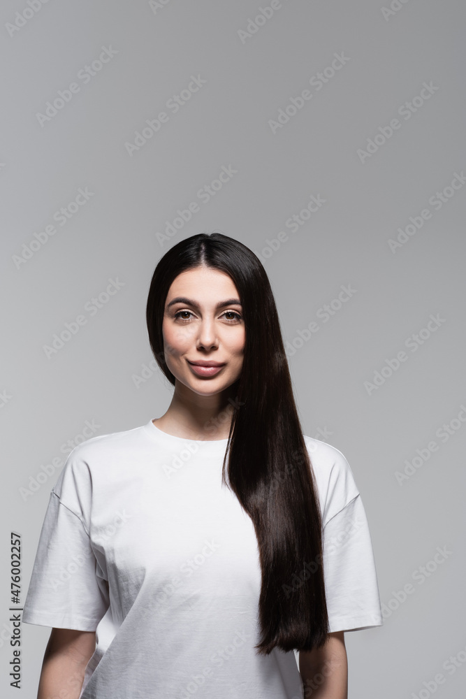 Fototapeta premium pleased woman with straight long hair isolated on grey