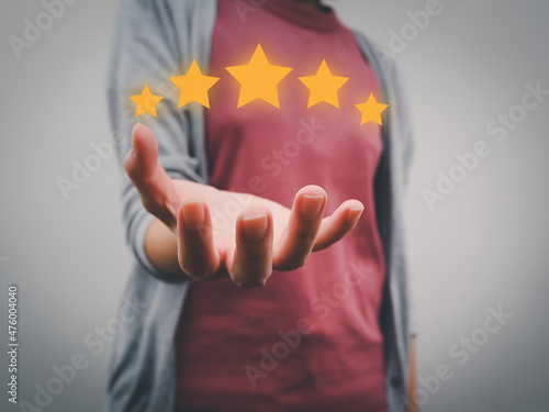The image is displayed on the palm of the hand. The customer satisfaction concept that gives five stars at a very satisfied level.