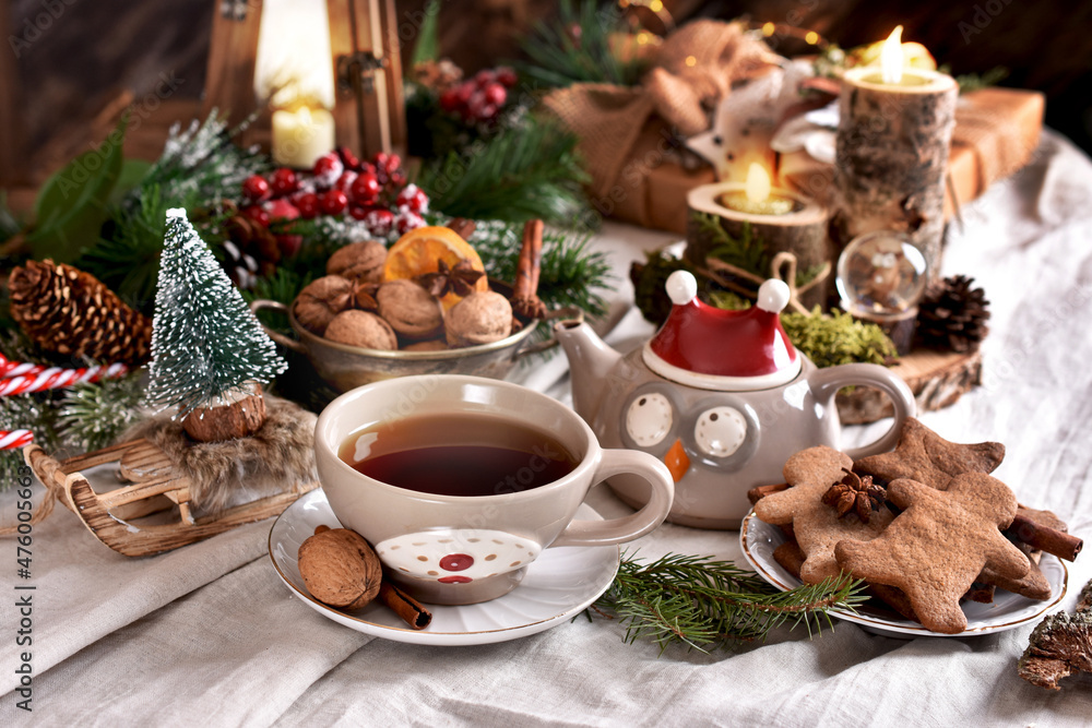 Hot tea and gingerbread cookies on Christmas table in rustic style