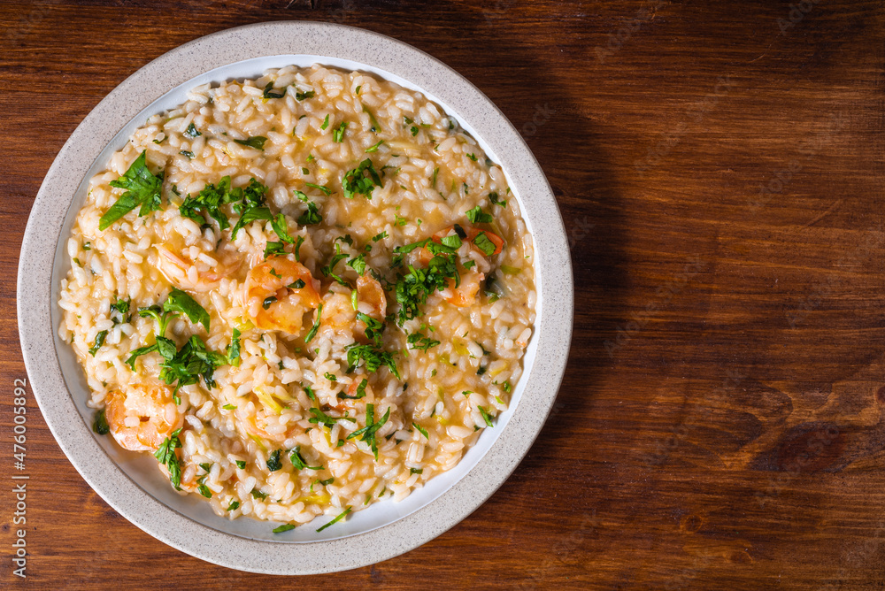 Portion of shrimp risotto on a plate, close-up, top view, copy space Portion of shrimp risotto on a plate, close-up, top view, copy space