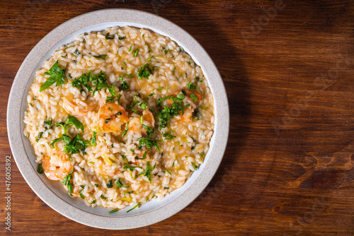 Portion of shrimp risotto on a plate, close-up, top view, copy space
