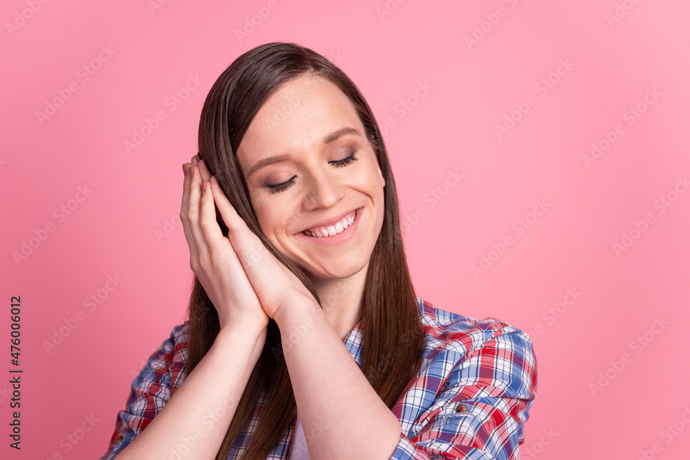Photo of young pretty woman arms touch cheeks enjoy break sleep drowse isolated over pink color background Photo of young pretty woman arms touch cheeks enjoy break sleep drowse isolated over pink color background