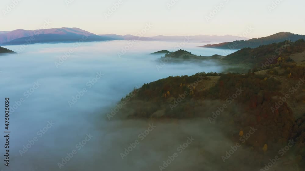 Mountains with colorful trees covered with layer of fog Mountains with colorful trees covered with layer of fog