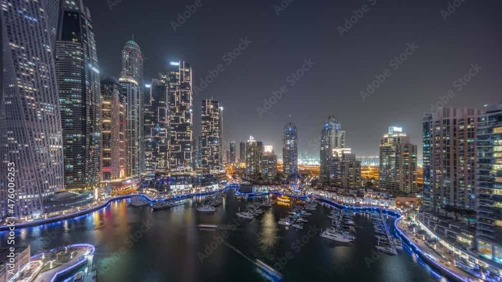 Dubai marina tallest skyscrapers and yachts in harbor aerial night timelapse. Dubai marina tallest skyscrapers and yachts in harbor aerial night timelapse.