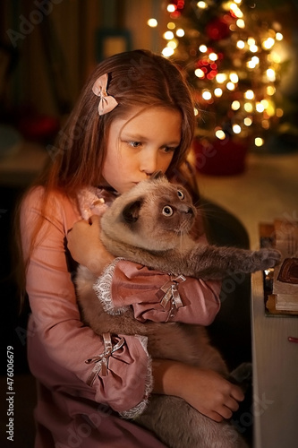 Christmas. herringbone with bokeh. girl kisses a cat. holiday magic. dark key
