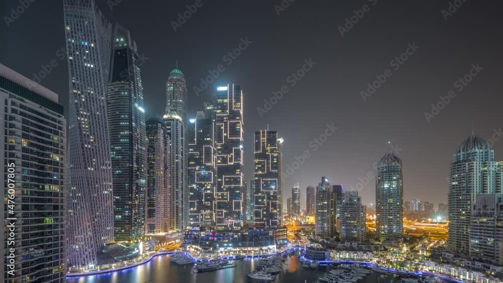 Dubai marina tallest skyscrapers and yachts in harbor aerial all night timelapse. Dubai marina tallest skyscrapers and yachts in harbor aerial all night timelapse.