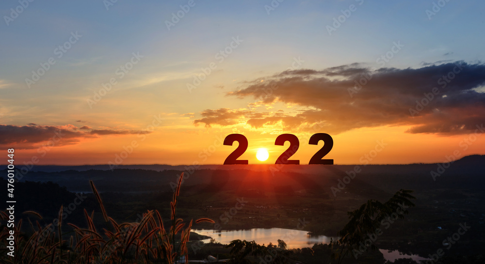 Φωτογραφία Happy New Year greeting card 2022, Silhouette number of 2022 letters on the mountain with sunset on mountains landscape in twilight time
