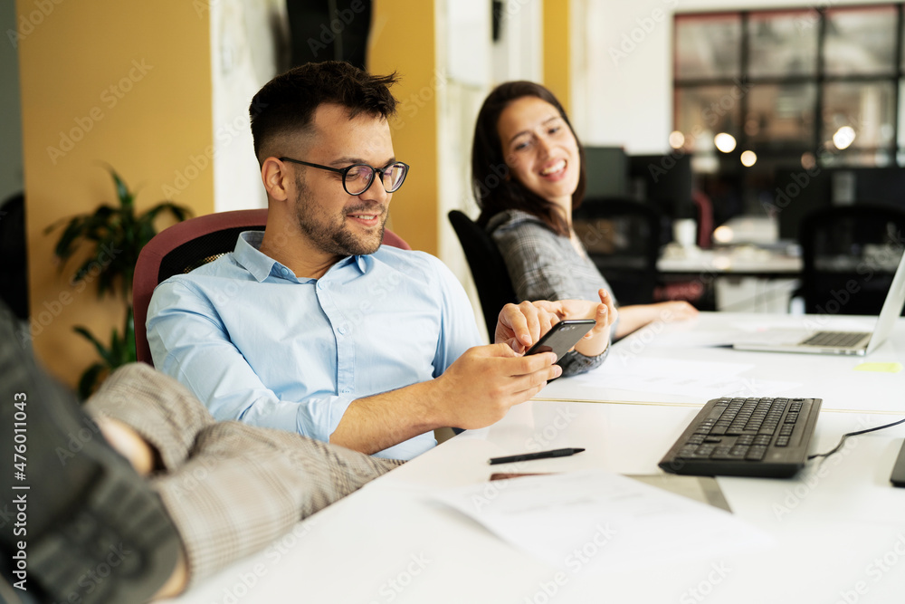 Colleagues in office. Businesswoman and businessman discussing work in office. Two friends working together Colleagues in office. Businesswoman and businessman discussing work in office. Two friends working together