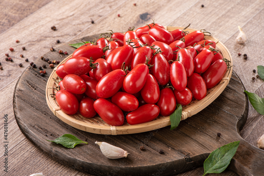 Fresh cherry tomatoes in a basket with spices. Fresh cherry tomatoes in a basket with spices.