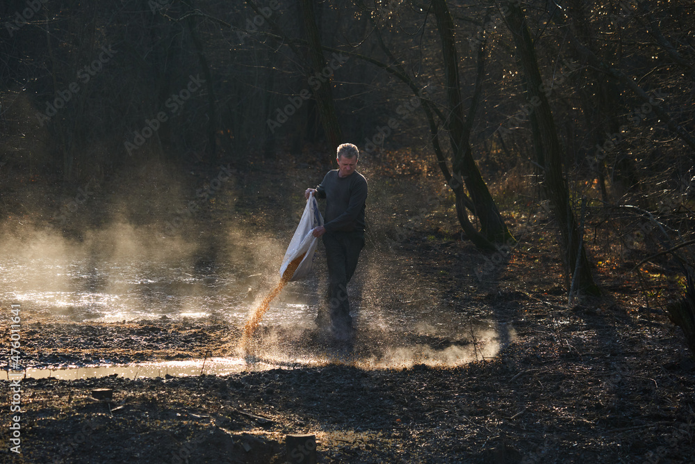 Game ranger spilling corn for animals Game ranger spilling corn for animals