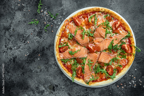 pizza with smoked salmon, red caviar, tomatoes and aragula ready to eat. banner, menu, recipe place for text, top view