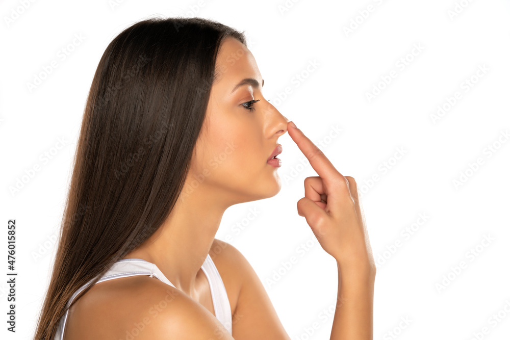 profile of a young serious woman touching her nose profile of a young serious woman touching her nose