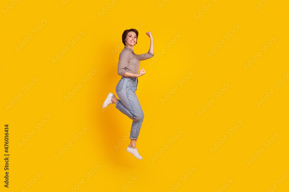 Full body profile side photo of young cheerful lady have fun jump celebrate victory isolated over yellow color background