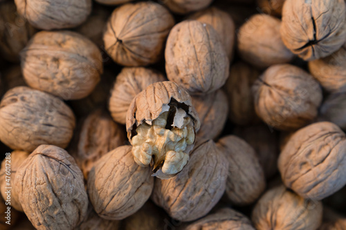 A cracked walnut and blurred walnuts in the background. Focus on cracked walnut. photo