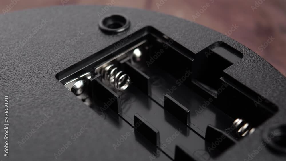 Opening the battery compartment of the black electronic device. Close-up connectors in slot. Macro. Power technology concept Opening the battery compartment of the black electronic device. Close-up connectors in slot. Macro. Power technology concept