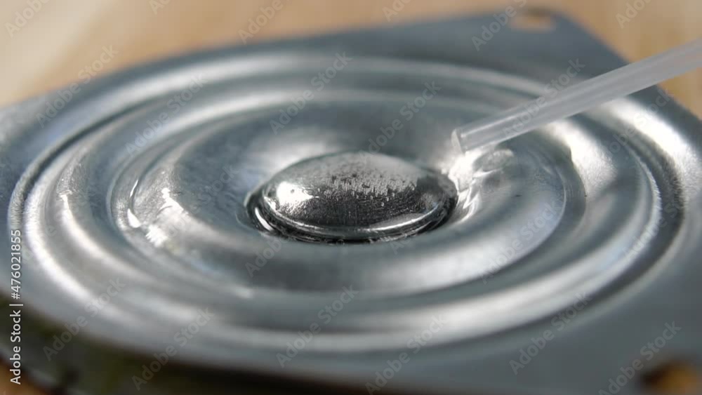 Lubricant spray is sprayed onto a metal mechanical part in slow motion. Macro. Industry service concept Lubricant spray is sprayed onto a metal mechanical part in slow motion. Macro. Industry service concept