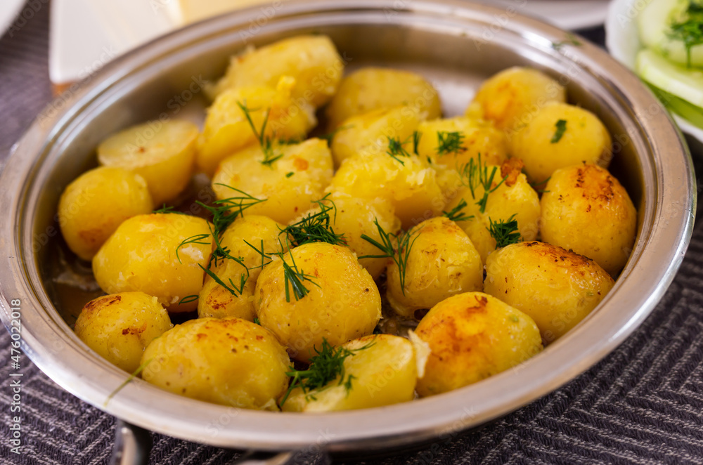 toasted young potatoes with dill in metal skillet toasted young potatoes with dill in metal skillet