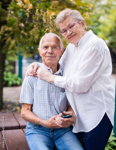 mature man with a woman sitting on bench in spring