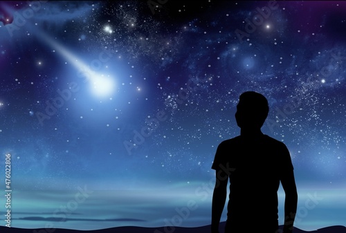 Silhouette of a young man enjoying countryside under the starry skies.