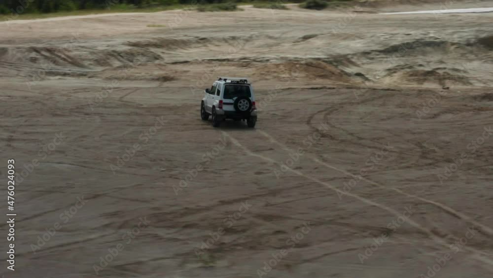 Aerial view of a car driving on sand Aerial view of a car driving on sand