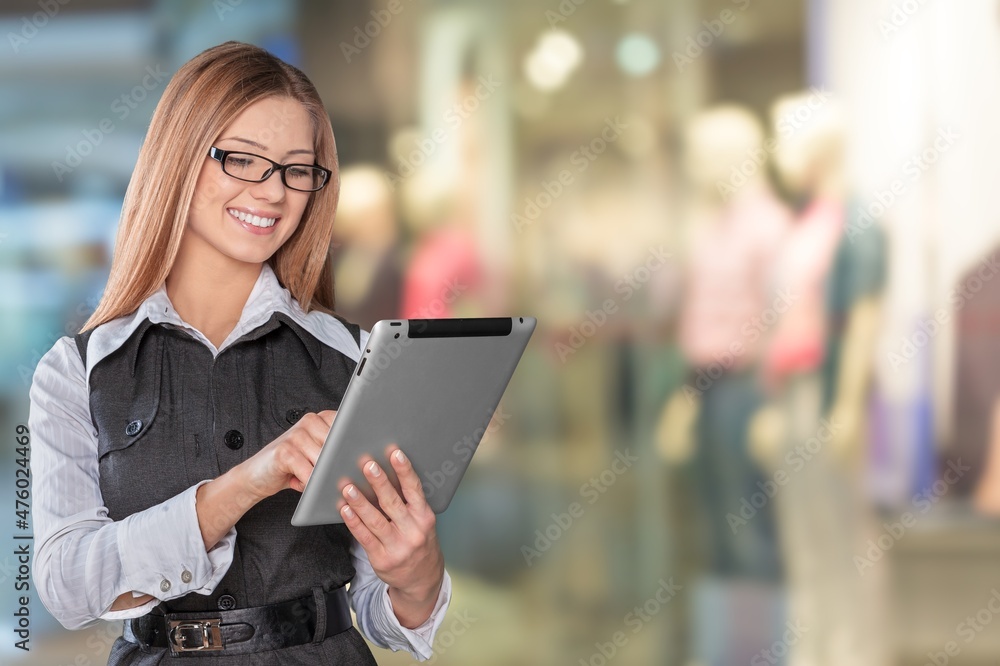 Fototapeta premium Clothing Store, Female Visual Merchandising Professional Uses Tablet Computer