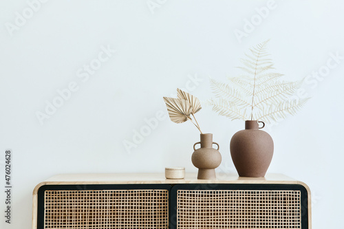 Fototapeta Modern scandinavian home interior with design wooden commode, dried leafs in ceramic vases and personal accessories in stylish home decor