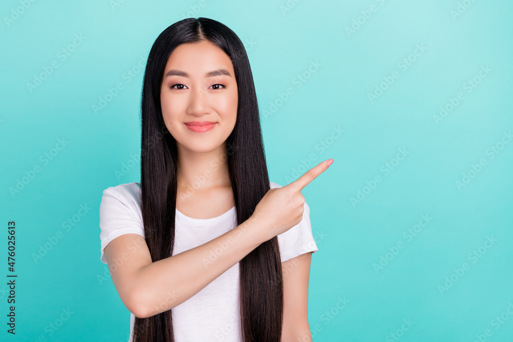 Photo of promoter lady direct finger empty space wear white t-shirt isolated turquoise color background Photo of promoter lady direct finger empty space wear white t-shirt isolated turquoise color background