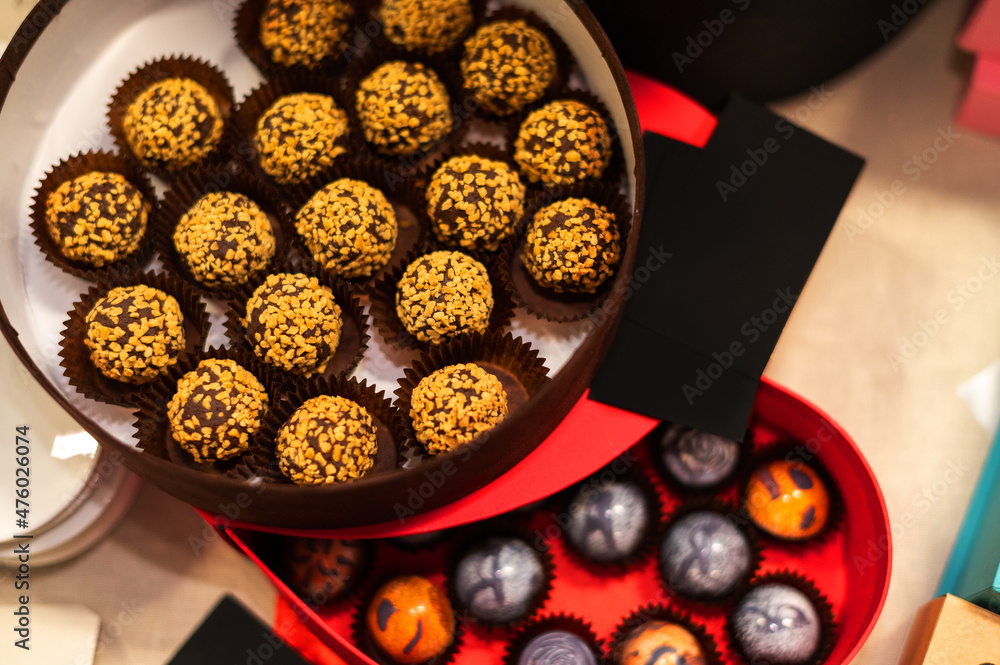 A box of truffle chocolates with nuts on the festive table.