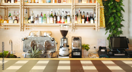 Bar and coffee shop environment blur background with coffee machine, bottle, Gin, Whisky, glass, grinder, counter bar and wooden table top.