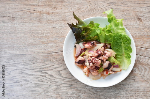 Thai spicy squid salad and fresh vegetable on plate